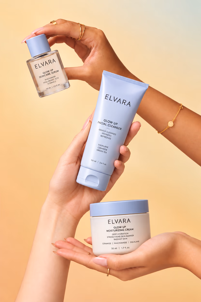 Hands holding up the Elvara serum, cleanser and cream against a warm backdrop